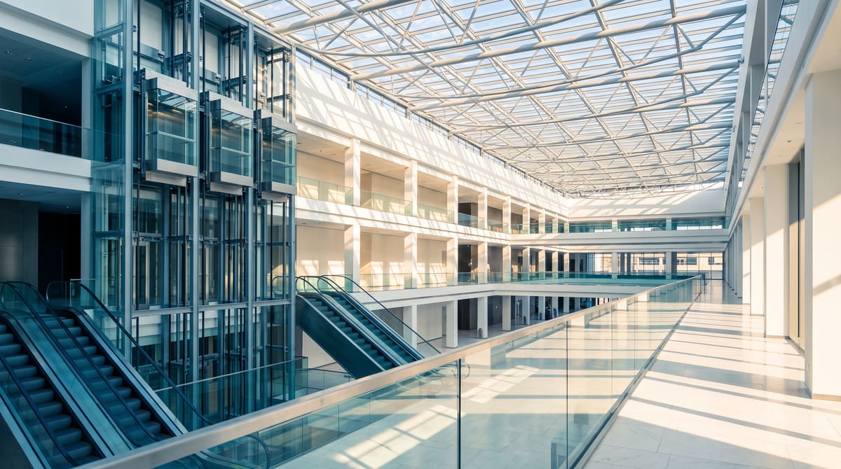 Escalators and passenger lifts in a bright, modern commercial building atrium